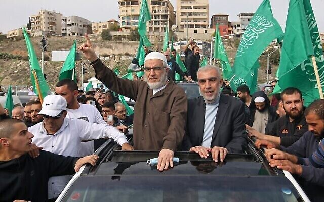 Cheikh Raed Salah (au centre gauche), le leader de la branche du nord du Mouvement islamique en Israël célébrant sa sortie de prison avec ses partisans, dans la ville d'Umm al-Fahm, dans le nord d'Israël, le 13 décembre 2021. (Crédit : Ahmad Gharabli/AFP) Cheikh Raed Salah (au centre gauche), le leader de la branche du nord du Mouvement islamique en Israël célébrant sa sortie de prison avec ses partisans, dans la ville d'Umm al-Fahm, dans le nord d'Israël, le 13 décembre 2021. (Crédit : Ahmad Gharabli/AFP)