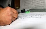 Jamal Rassoul Hussein, un Irakien de 50 ans, pratique la calligraphie arabe dans l'atelier de sa maison dans la ville de Rania, à quelque 130 km au nord de Suleymaniyah, dans la région autonome du Kurdistan irakien, le 17 décembre 2021. (Crédit : Shwan MOHAMMED / AFP)