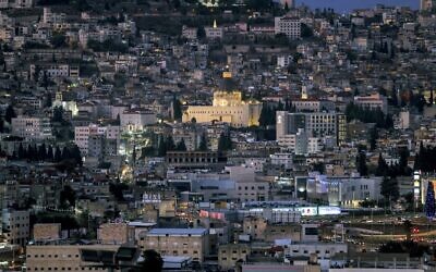 Vue générale de la ville de Nazareth, au nord d'Israël, et de sa basilique catholique de l'Annonciation (centre), où la tradition chrétienne catholique veut que l'ange Gabriel soit apparu à la Vierge Marie pour lui annoncer sa conception de Jésus-Christ (construite au-dessus de la grotte où elle aurait vécu à l'époque), le 18 décembre 2021. (Crédit : Ahmad Gharabli/AFP)