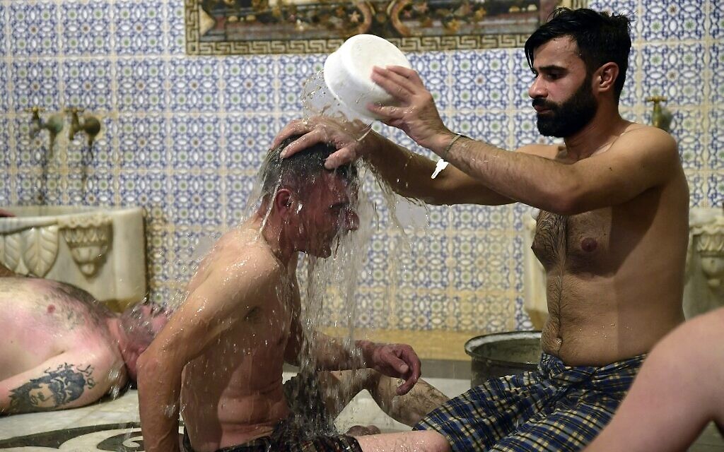 Des hommes se baignent à Hammam al-Qawas, un bain turc traditionnel, dans la ville d'Alep, au nord de la Syrie, le 16 décembre 2021. (Crédit : AFP)