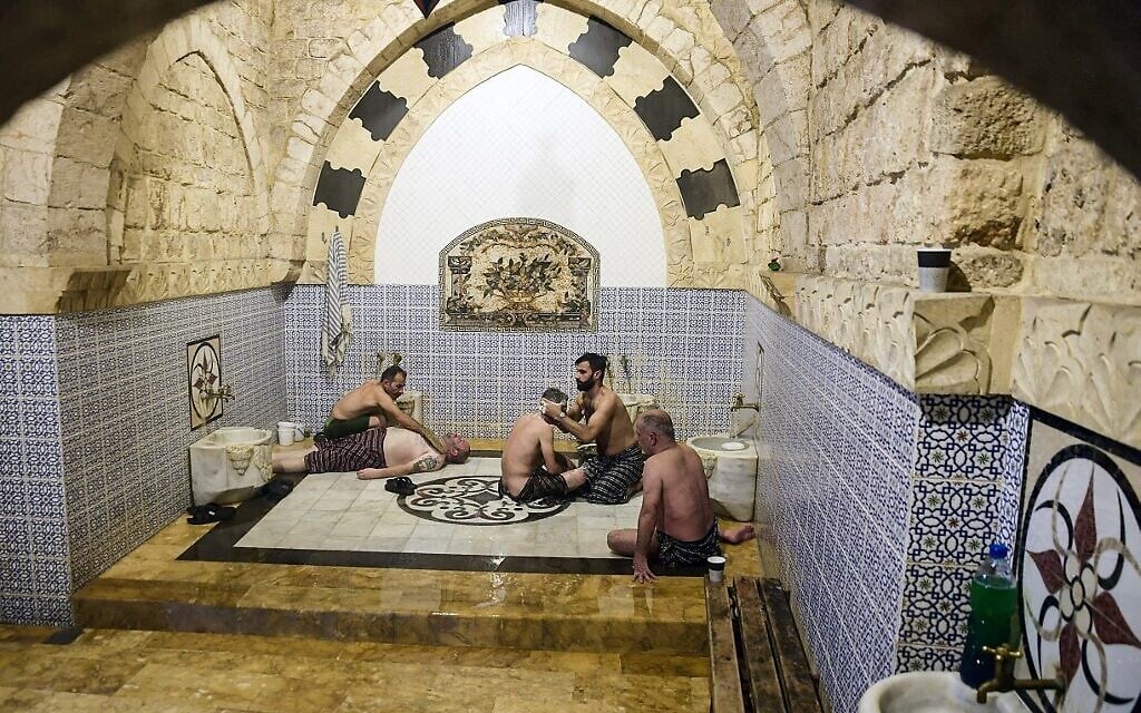 Des hommes se baignent à Hammam al-Qawas, un bain turc traditionnel, dans la ville d'Alep, au nord de la Syrie, le 16 décembre 2021. (Crédit : AFP)