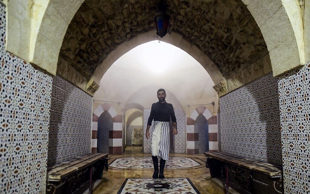 Des hommes se baignent à Hammam al-Qawas, un bain turc traditionnel, dans la ville d'Alep, au nord de la Syrie, le 16 décembre 2021. (Crédit : AFP)