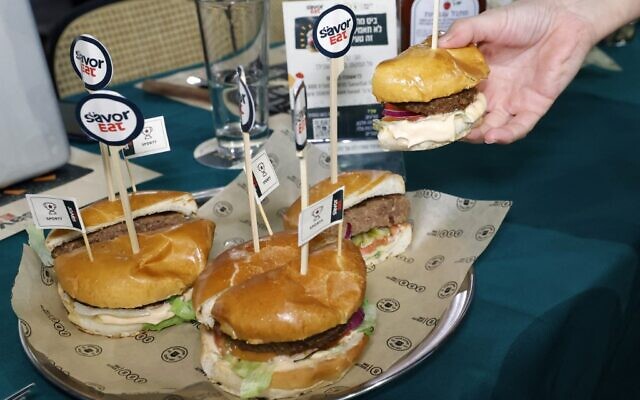 Cette photo prise le 28 décembre 2021 montre des moitiés de hamburgers à base de plantes au goût de viande, fabriqués et cuits par un robot selon les besoins des clients, proposés par la marque israélienne de restauration rapide BBB, à Herzliya. (Crédit : JACK GUEZ / AFP) Cette photo prise le 28 décembre 2021 montre des moitiés de hamburgers à base de plantes au goût de viande, fabriqués et cuits par un robot selon les besoins des clients, proposés par la marque israélienne de restauration rapide BBB, à Herzliya. (Crédit : JACK GUEZ / AFP)