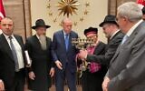 Les membres de l'Alliance des rabbins des États islamiques (ARIS) offrent au président turc Recep Tayyip Erdogan une ménorah décorée au nom de la communauté juive de Turquie pendant une rencontre au palais présidentiel d'Ankara, le 23 décembre 2021. De gauche à droite : Akif Gilalov, chef du Congrès mondial des Juifs des montagnes ; Berel Lazar, grand-rabbin de Russie ; Erdogan; Isak Haleva, grand rabbin séfarade de Turquie;  le rabbin Mendy Chitrik, directeur de l'ARIS; Erol Kohen, président de la communauté juive turque. (Crédit : David I. Klein/JTA)