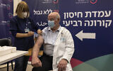 Le professeur Jacov Lavee recevant la quatrième dose de vaccin Pfizer-BioNTech contre la COVID-19 à l'hôpital Sheba de Ramat Gan, le 27 décembre 2021. (Crédit : AP Photo/Tsafrir Abayov)