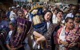 Des membres des mouvements réformé et massorti avec des rouleaux de Torah pendant une prière mixte sur la place publique qui est devant le mur Occidental, dans la Vieille Ville de Jérusalem, le 18 mai 2017. (Crédit : Yonatan Sindel/Flash90)
