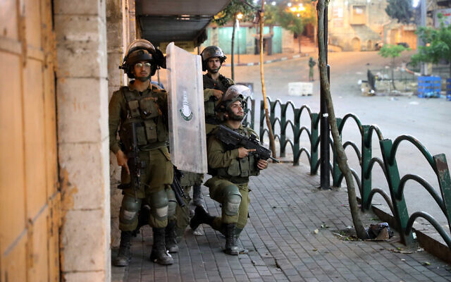 Photo d'illustration : Des soldats israéliens se préparent pendant des affrontements avec des Palestiniens dans la ville de Hébron, en Cisjordanie, le 12 mai 2021. (Crédit : Wissam Hashlamoun/Flash90) Photo d'illustration : Des soldats israéliens se préparent pendant des affrontements avec des Palestiniens dans la ville de Hébron, en Cisjordanie, le 12 mai 2021. (Crédit : Wissam Hashlamoun/Flash90)