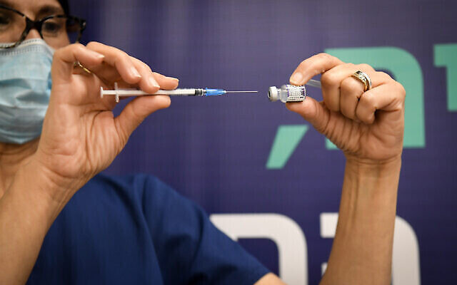 Un employé du secteur de la santé prépare un vaccin contre la COVID-19 à l'hôpital Sheba de Ramat Gan, le 28 décembre 2021. (Crédit : Yossi Zeliger/Flash90) Un employé du secteur de la santé prépare un vaccin contre la COVID-19 à l'hôpital Sheba de Ramat Gan, le 28 décembre 2021. (Crédit : Yossi Zeliger/Flash90)