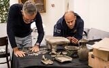 Des enquêteurs examinent des objets saisis par la police qui datent probablement de la révolte de Bar Kochba contre les Romains. (Crédit : Yoli Schwartz/Israel Antiquities Authority)