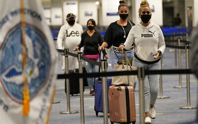Des passagers internationaux arrivant à l'aéroport international de Miami avant d'être contrôlés par le service américain des douanes et de la protection des frontières (CBP) qui utilise la biométrie faciale pour automatiser les contrôles manuels des documents requis pour l'admission aux États-Unis, à Miami, en Floride, le 20 novembre 2020. (Crédit : Lynne Sladky/AP)