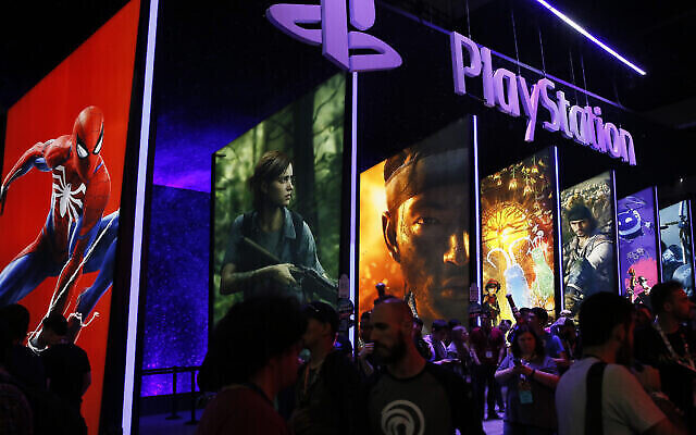 Des personnes se tiennent en ligne à côté du stand PlayStation lors de la 24e Electronic Entertainment Expo E3 au Los Angeles Convention Center, le 14 juin 2018. Sony a déclaré le 16 septembre 2020 que sa prochaine console de jeux vidéo PlayStation 5 coûterait environ 1550 shekels et serait lancée le 12 novembre. (Crédit : AP Photo/Damian Dovarganes, Dossier) Des personnes se tiennent en ligne à côté du stand PlayStation lors de la 24e Electronic Entertainment Expo E3 au Los Angeles Convention Center, le 14 juin 2018. Sony a déclaré le 16 septembre 2020 que sa prochaine console de jeux vidéo PlayStation 5 coûterait environ 1550 shekels et serait lancée le 12 novembre. (Crédit : AP Photo/Damian Dovarganes, Dossier)
