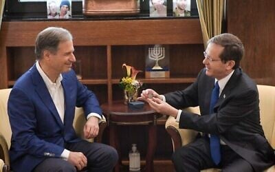Le président Isaac Herzog, à gauche, présente à l'astronaute israélien Eytan Stibbe un cube en verre portant une prière pour le bien-être de l'État d'Israël, à la résidence du président à Jérusalem, le 16 décembre 2021. (Crédit : Kobi Gideon/GPO)