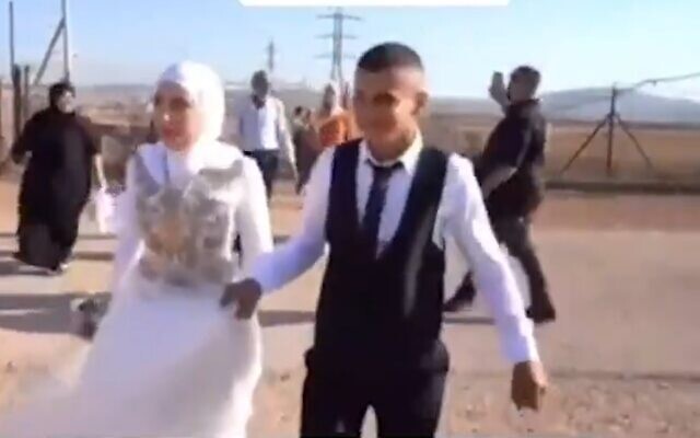 Capture d'écran d'une vidéo montrant une mariée et un marié palestiniens traversant en Israël par une brèche dans la barrière de sécurité de Cisjordanie. (Crédit : Twitter)