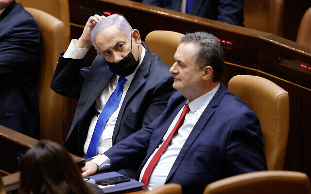 Le Premier ministre Benjamin Netanyahu et le ministre des Finances de l'époque, Israel Katz, assistent à la prestation de serment du nouveau gouvernement, à la Knesset à Jérusalem, le 13 juin 2021. (Olivier Fitoussi/Flash90) Le Premier ministre Benjamin Netanyahu et le ministre des Finances de l'époque, Israel Katz, assistent à la prestation de serment du nouveau gouvernement, à la Knesset à Jérusalem, le 13 juin 2021. (Olivier Fitoussi/Flash90)