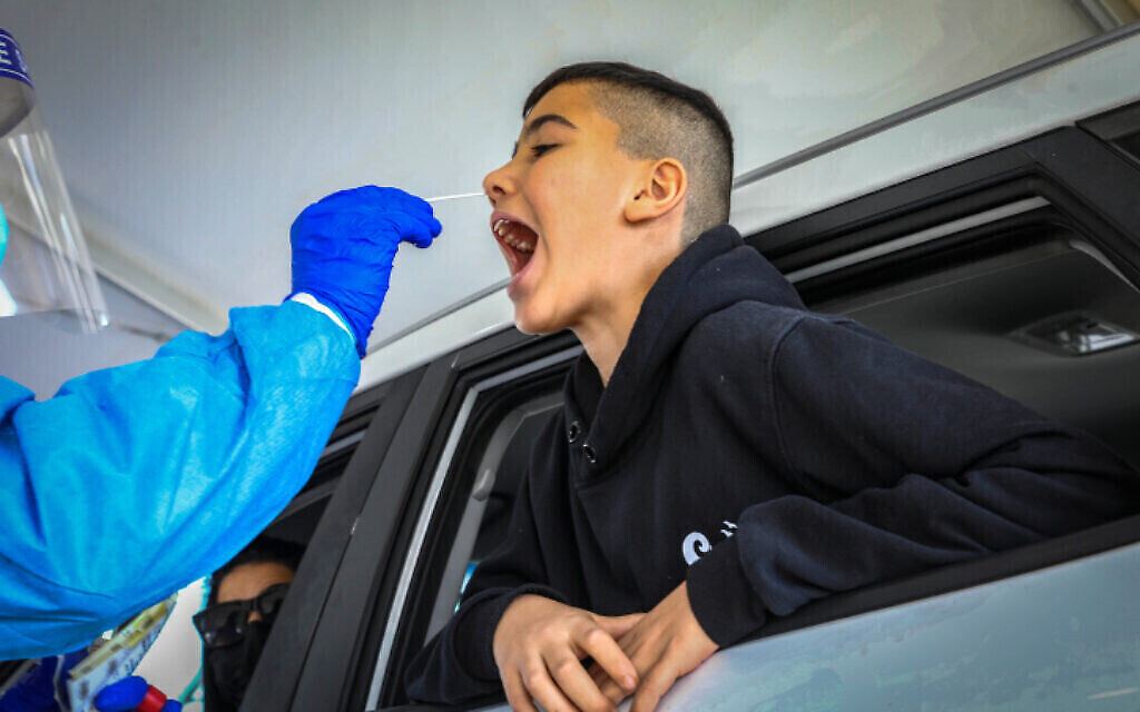 Un enfant subit un test de dépistage du COVID-19, à Modiin, le 26 décembre 2021. (Yossi Aloni/Flash90) Un enfant subit un test de dépistage du COVID-19, à Modiin, le 26 décembre 2021. (Yossi Aloni/Flash90)