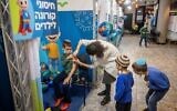 Des enfants âgés de 5 à 11 ans reçoivent leur première dose de vaccin Covid-19, au centre de vaccination Clallit à Jérusalem, le 25 novembre 2021. (Crédit : Yonatan Sindel/Flash90