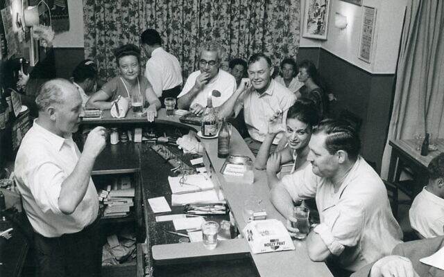 Rassemblement chez Fink's, un bar apprécié de Jérusalem, dans "Nes ou Turc", une exposition sur les premiers cafés de Jérusalem au café Tmol Shilshom à Jérusalem jusqu'au 31 décembre 2021. (Crédit : Collection privée/Autorisation)