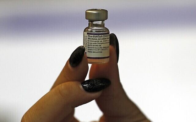 Une infirmière montre un flacon de vaccin Pfizer-BioNtech contre le COVID-19 à la caisse d'assurance-maladie Maccabi, à Jérusalem, le 20 août 2021. (Crédit : Ahmad Gharabli/AFP) Une infirmière montre un flacon de vaccin Pfizer-BioNtech contre le COVID-19 à la caisse d'assurance-maladie Maccabi, à Jérusalem, le 20 août 2021. (Crédit : Ahmad Gharabli/AFP)
