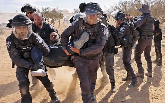 La police israélienne arrête un homme lors d'une manifestation des Bédouins contre un programme de reboisement entrepris par le KKL-JNF dans le sud du Negev, le 12 janvier 2022. (Crédit : AHMAD GHARABLI / AFP) La police israélienne arrête un homme lors d'une manifestation des Bédouins contre un programme de reboisement entrepris par le KKL-JNF dans le sud du Negev, le 12 janvier 2022. (Crédit : AHMAD GHARABLI / AFP)