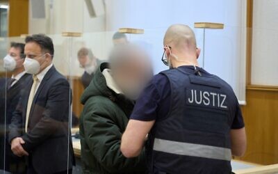 Illustration : L'ancien officier de renseignement syrien Anwar Raslan (centre) arrive dans la salle d'audience d'un tribunal de Coblence, dans l'ouest de l'Allemagne, le 13 janvier 2022, au dernier jour de son procès où il a été condamné à la prison à vie pour crimes contre l'humanité lors du premier procès mondial sur la torture d'État en Syrie. (Crédit : Thomas Frey / POOL / AFP)