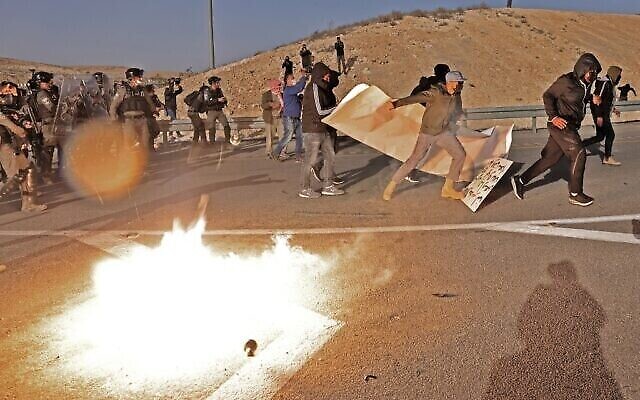 Des manifestants bédouins et des forces israéliennes s'affrontent lors d'une manifestation dans le village de Sawe al-Atrash, dans le sud d'Israël, dans le désert du Neguev, contre un projet de boisement du Fonds national juif (FNJ), le 13 janvier 2022. (Crédit : Menahem KAHANA / AFP)