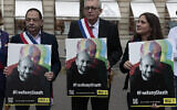 Des fonctionnaires français tiennent des portraits de Ramy Shaath lors d'un rassemblement près de l'ambassade d'Égypte à Paris, le 23 juin 2021. (Crédit 
: AP Photo/ Lewis Joly)