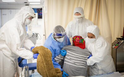 Des membres de l'équipe de l'hôpital Shaare Zedek dans le service des coronavirus de l'hôpital Shaare Zedek à Jérusalem, le 11 janvier 2022. (Crédit : Yonatan Sindel/Flash90)