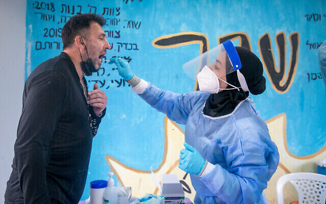 Une infirmière fait un test antigénique dans un centre de dépistage de Beit Hashmonai, le 16 janvier 2022. (Crédit : Yossi Aloni/Flash90) Une infirmière fait un test antigénique dans un centre de dépistage de Beit Hashmonai, le 16 janvier 2022. (Crédit : Yossi Aloni/Flash90)