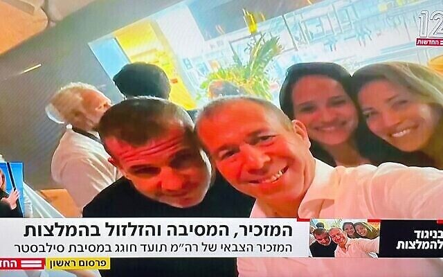 Le secrétaire militaire du gouvernement Avi Gil (à droite) pose pour un selfie avec le porte-parole de NSO Oded Hershkovitz lors d'une fête du Nouvel An à Tel Aviv. (Capture d'écran de Channel 12) Le secrétaire militaire du gouvernement Avi Gil (à droite) pose pour un selfie avec le porte-parole de NSO Oded Hershkovitz lors d'une fête du Nouvel An à Tel Aviv. (Capture d'écran de Channel 12)