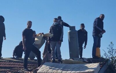 Des Palestiniens résistant à une expulsion de la municipalité de Jérusalem sur le toit de leur maison, à Sheikh Jarrah, le 17 janvier 2022. (Autorisation)
