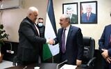 Le nouveau ministre de l'Intérieur palestinien Ziad Hab al-Reeh serre la main du Premier ministre de l'Autorité palestinienne Mohammad Shtayyeh après avoir reçu officiellement son portefeuille, le 2 janvier 2021. (Crédit : WAFA)