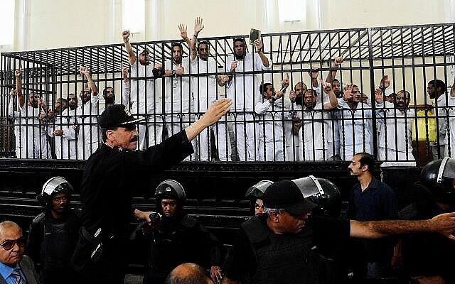 Illustration : Les partisans des Frères musulmans et d'autres islamistes font des gestes depuis la cage des accusés alors qu'ils reçoivent des sentences dans un procès de masse à Alexandrie, en Égypte, le 19 mai 2014. (AP Photo/Heba Khamis) Illustration : Les partisans des Frères musulmans et d'autres islamistes font des gestes depuis la cage des accusés alors qu'ils reçoivent des sentences dans un procès de masse à Alexandrie, en Égypte, le 19 mai 2014. (AP Photo/Heba Khamis)