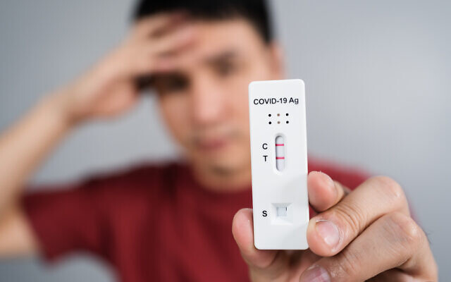 Photo d'illustration : Un jeune homme vient d'être dépisté positif à la COVID-19, montrant son test. (Crédit : iStock via Getty Images)