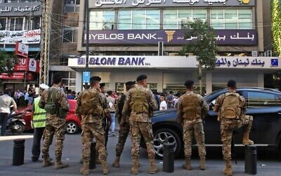 Des membres de l'armée libanaise entourent des manifestants qui se rassemblent devant une banque lors de manifestations continues contre la corruption, le 4 novembre 2019 à Sidon, capitale du sud du Liban. (Mahmoud ZAYYAT / AFP)