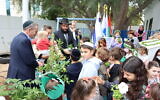 Le rabbin Levi Duchman et le consul général d'Israël à Dubaï Ilan Sztulman et des enfants lors d'un événement de plantation d'arbres à Tou Bichvat aux EAU. (Autorisation)
