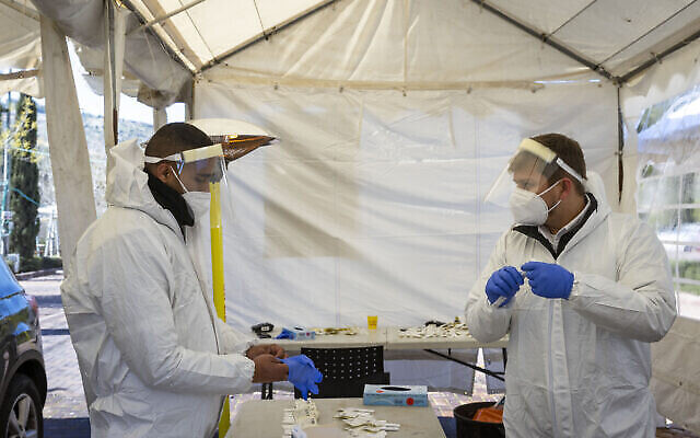 Des agents de santé dans un complexe d'essais en voiture à Jérusalem, le 17 janvier 2022. (Olivier Fitoussi/Flash90) Des agents de santé dans un complexe d'essais en voiture à Jérusalem, le 17 janvier 2022. (Olivier Fitoussi/Flash90)