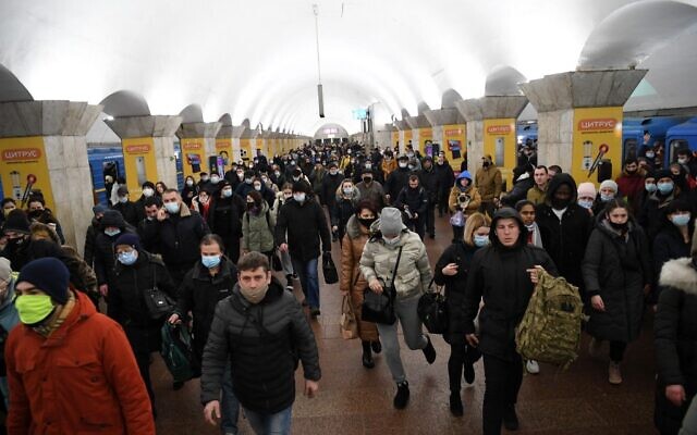Des personnes, certaines portant des sacs et des valises, marchent dans une station de métro à Kiev, tôt le 24 février 2022. (Crédit : Daniel LEAL / AFP) Des personnes, certaines portant des sacs et des valises, marchent dans une station de métro à Kiev, tôt le 24 février 2022. (Crédit : Daniel LEAL / AFP)