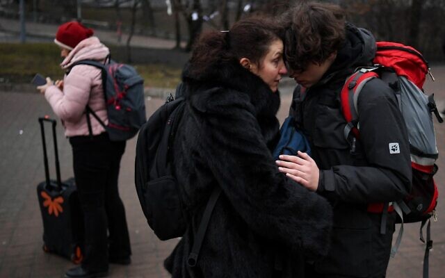 Des personnes s'enlacent devant une station de métro à Kiev, dans la matinée du 24 février 2022. (Crédit : Daniel LEAL / AFP) Des personnes s'enlacent devant une station de métro à Kiev, dans la matinée du 24 février 2022. (Crédit : Daniel LEAL / AFP)