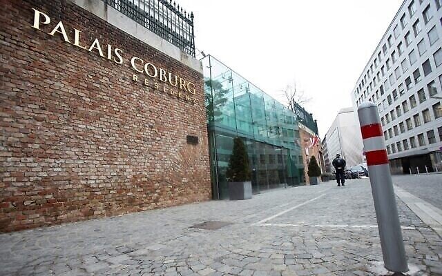 Un policier marche devant le Palais Coburg de Vienne, où se déroulent les négociations nucléaires à huis clos avec l'Iran, le 27 décembre 2021. (Crédit : ALEX HALADA / AFP)