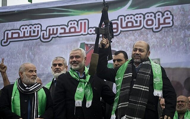 Les dirigeants du Hamas de Gaza Ismail Haniya, au centre, et Mousa Abu Marzouq, à droite, brandissent une arme en saluant des partisans lors d'un défilé marquant le 27e anniversaire de la création du mouvement islamiste le 14 décembre 2014 dans la ville de Gaza. (Crédit: AFP/MAHMUD HAMS) Les dirigeants du Hamas de Gaza Ismail Haniya, au centre, et Mousa Abu Marzouq, à droite, brandissent une arme en saluant des partisans lors d'un défilé marquant le 27e anniversaire de la création du mouvement islamiste le 14 décembre 2014 dans la ville de Gaza. (Crédit: AFP/MAHMUD HAMS)