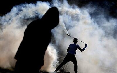 Des manifestants palestiniens affrontent les forces de sécurité israéliennes, le 13 janvier 2018, dans le village de Nabi Saleh, en Cisjordanie. (Crédit : AFP / ABBAS MOMANI)