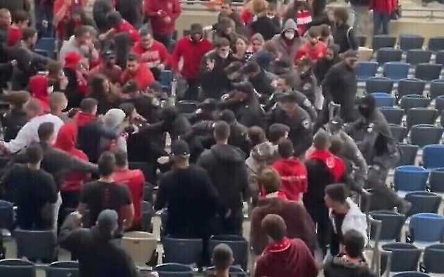 Des policiers se bagarrant avec des supporters de football lors d'un match au stade Sammy Ofer de Haïfa, le 21 février 2022. (Capture d'écran Twitter) Des policiers se bagarrant avec des supporters de football lors d'un match au stade Sammy Ofer de Haïfa, le 21 février 2022. (Capture d'écran Twitter)