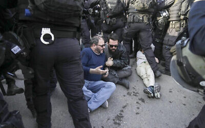Les agents de la police anti-émeute israélienne affrontent les manifestants pendant un mouvement de protestation en solidarité avec les résidents palestiniens du quartier Sheikh Jarrah de Jérusalem-Est, le 18 février 2022.  En Polo bleu, le député de la Liste arabe unie Ofer Cassif. (Crédit : AP Photo/Mahmoud Illean)
