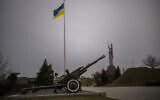 Un enfant joue avec canon antiaérien au musée de la guerre, à Kiev, en Ukraine, le 23 février 2022. (Crédit : AP/Emilio Morenatti)