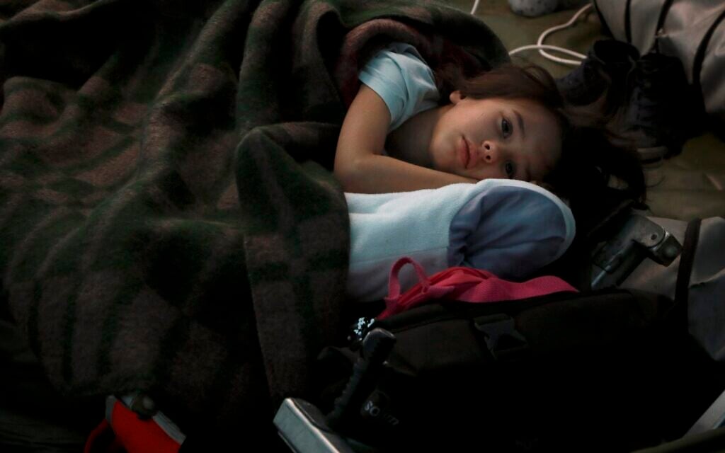 Un enfant ukrainien dort dans une tente faisant partie d'un centre humanitaire pour réfugiés à la frontière moldavo-ukrainienne, à Palalanca, en Moldavie, vendredi 25 février 2022. (Crédit : AP Photo/Aurel Obreja)