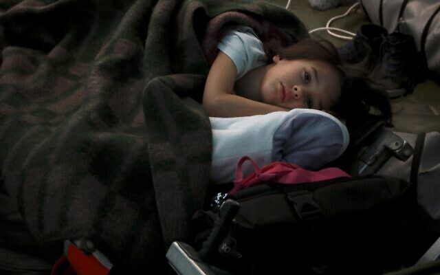 Un enfant ukrainien dort dans une tente faisant partie d'un centre humanitaire pour réfugiés à la frontière moldavo-ukrainienne, à Palalanca, en Moldavie, vendredi 25 février 2022. (Crédit : AP Photo/Aurel Obreja)