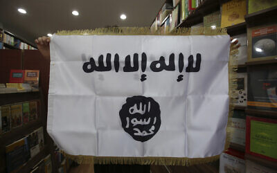 Sur cette photo du 13 octobre 2014, un homme montre un drapeau de l'EI dans une librairie islamique du quartier de Fatih à Istanbul (AP Photo/Emrah Gurel)