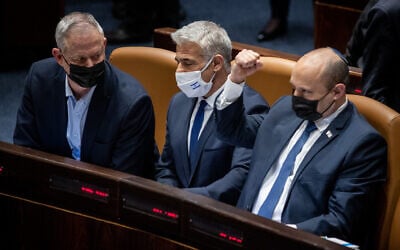 Le Premier ministre Naftali Bennett, à droite, et le ministre des Affaires étrangères, Yair Lapid, avec le ministre de la Défense, Benny Gantz à gauche au cours du vote consacré à la loi sur le recrutement militaire ultra-orthodoxe à la Knesset, le 31 janvier 2022. (Crédit : Flash90)