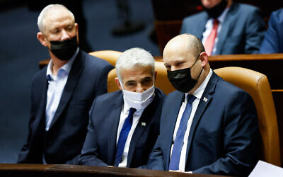 Le Premier ministre Naftali Bennett, à droite, et le ministre des Affaires étrangères, Yair Lapid, avec le ministre de la Défense, Benny Gantz à gauche au cours du vote consacré à la loi sur le recrutement militaire ultra-orthodoxe à la Knesset, le 31 janvier 2022. (Crédit : Olivier Fitoussi/Flash90)