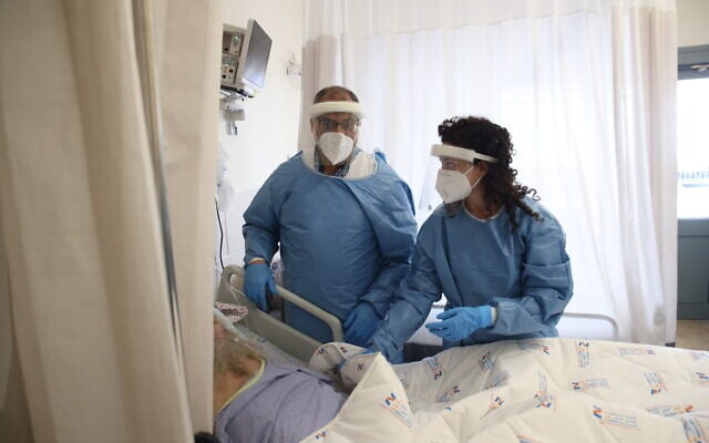 Des employés de l'hôpital Ziv en combinaison de protection dans l'unité coronavirus de l'hôpital à Safed, le 1er février 2022. (Crédit : David Cohen/Flash90) Des employés de l'hôpital Ziv en combinaison de protection dans l'unité coronavirus de l'hôpital à Safed, le 1er février 2022. (Crédit : David Cohen/Flash90)